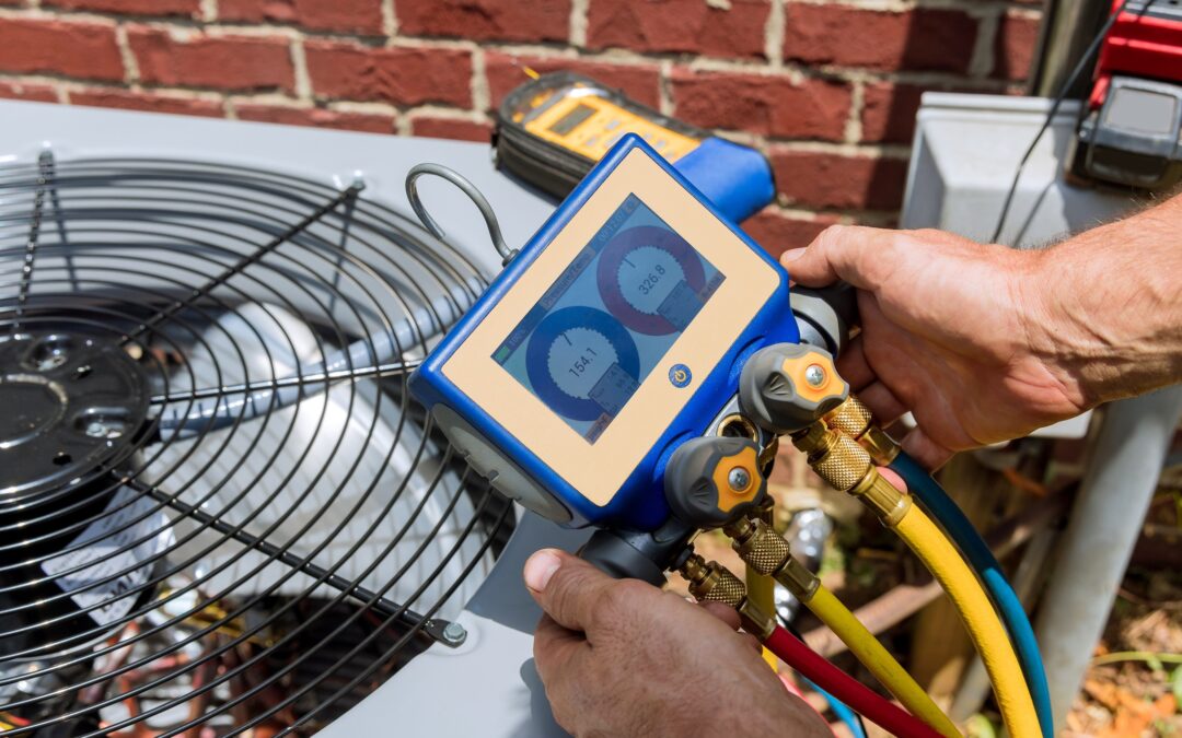 Close up of a man holding a monitor to test the performance of a central air conditioning unit.