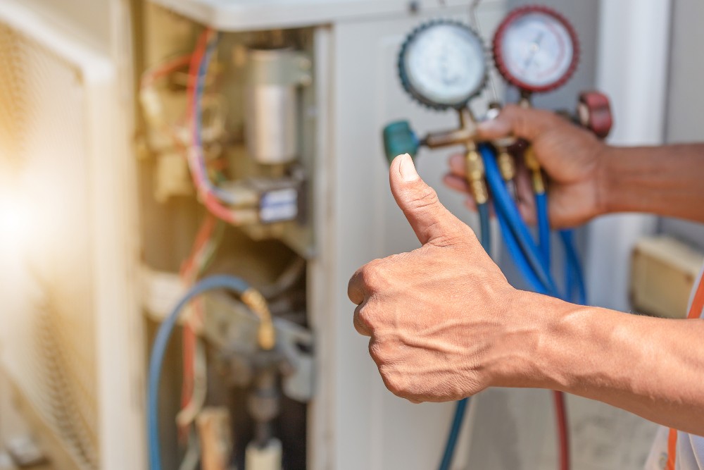 Close up of a thumbs up from an HVAC technician who is fixing an air conditioning unit in Youngstown, Ohio.